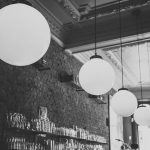 black and white image of lights in a brick restaurant